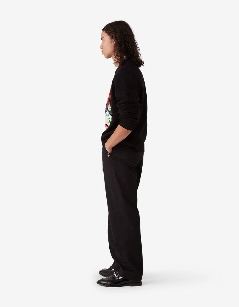 Casablanca Black Chino Trousers MPF25-TR-321-01. Model wearing a black sweater with colourful designs and black pants