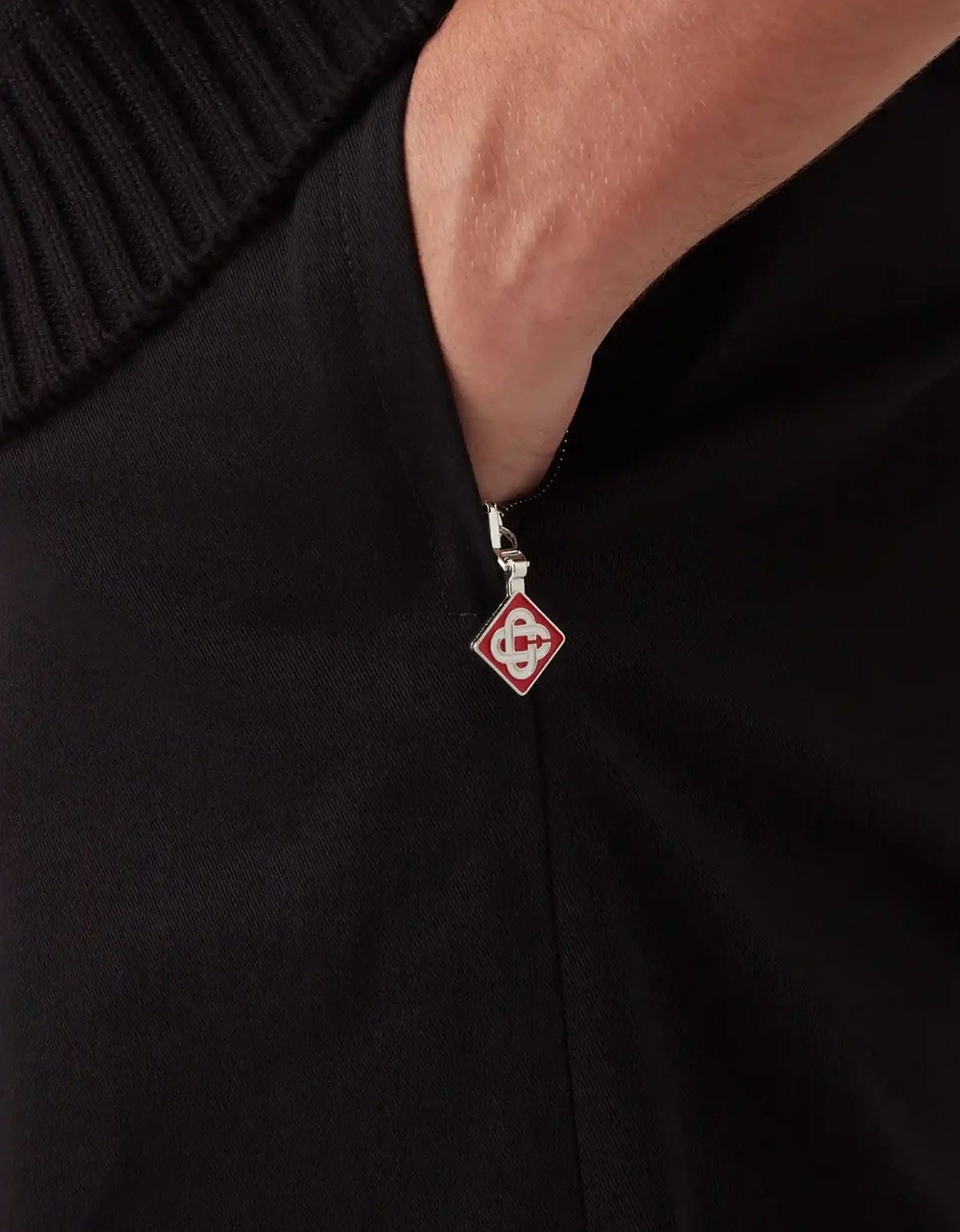 Casablanca Black Chino Trousers MPF25-TR-321-01. Close up of Casablanca logo on the pocket zip pull