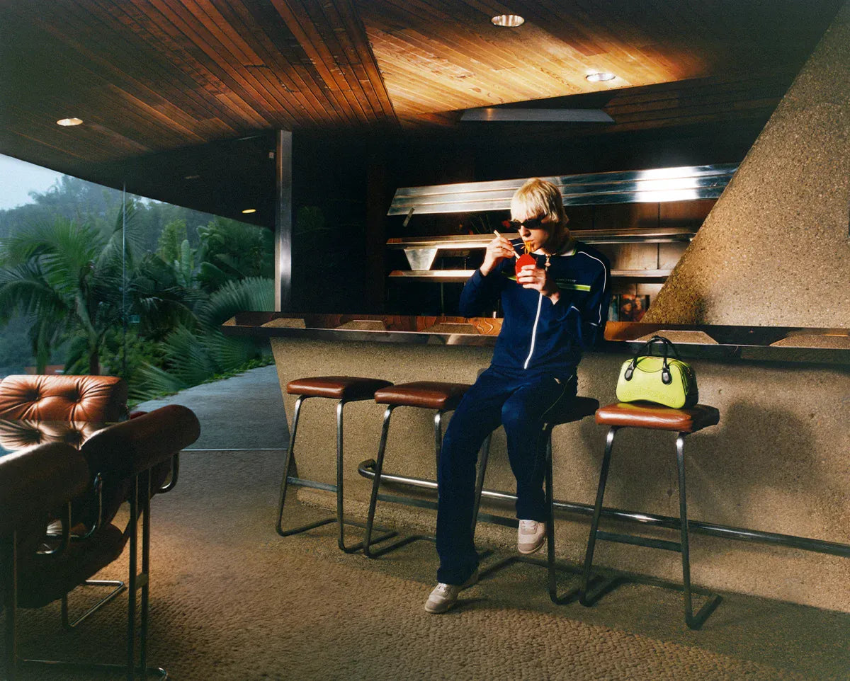 Casablanca SS26. Person sitting on a bar stool in a modern outdoor kitchen area.