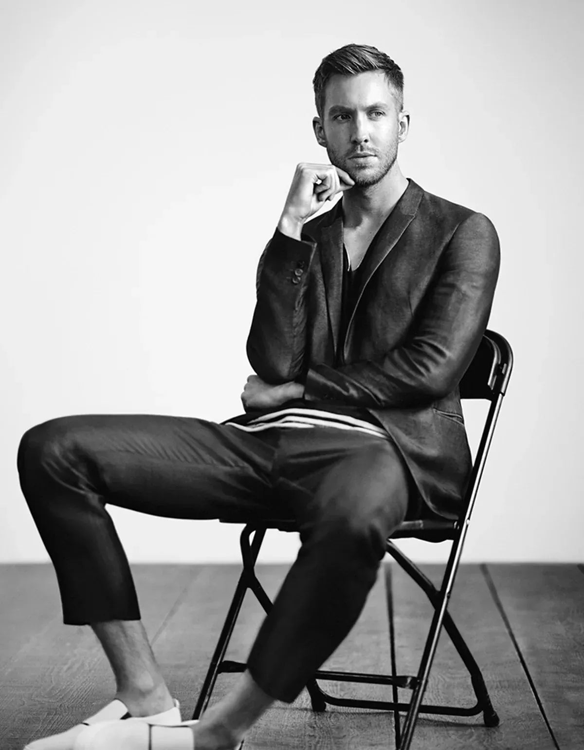 Emprio Armani clothing for men. Man in a suit sitting on a chair with a neutral background