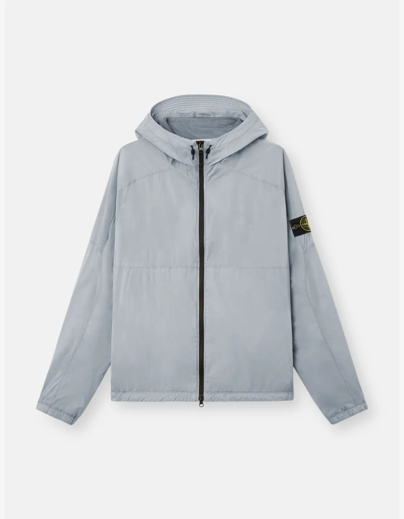 A light gray hooded windbreaker jacket with a black front zipper and the Stone Island compass logo patch on the left sleeve, displayed on a clean light gray background.