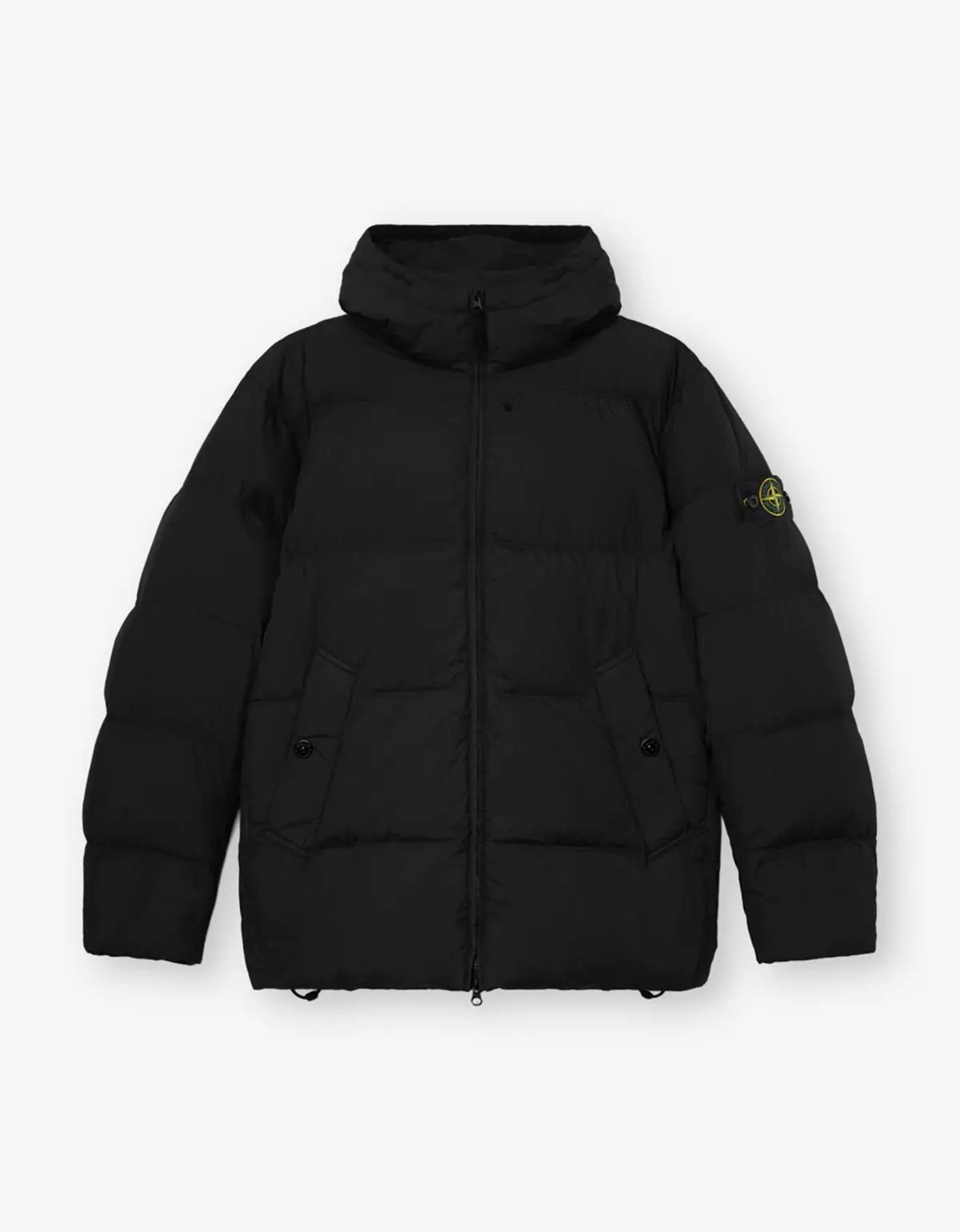 A black hooded puffer jacket with horizontal quilting, a front zipper, and a small yellow-green Stone Island compass logo patch on the left sleeve, shown against a light gray background.