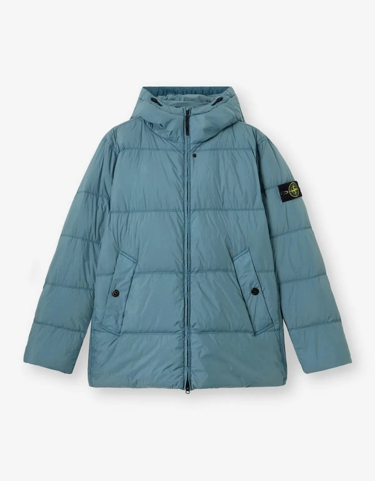 A light blue hooded puffer jacket with horizontal quilting, a front zipper, and a black Stone Island logo patch on the left sleeve, displayed against a light gray background.