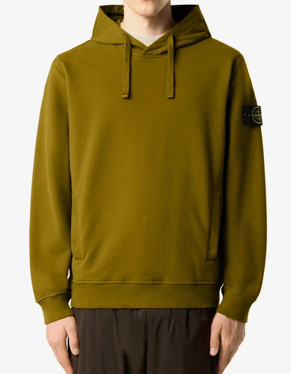 A person wearing an olive green Stone Island pullover hoodie with the brand's signature compass patch on the left sleeve, shown against a plain white background.