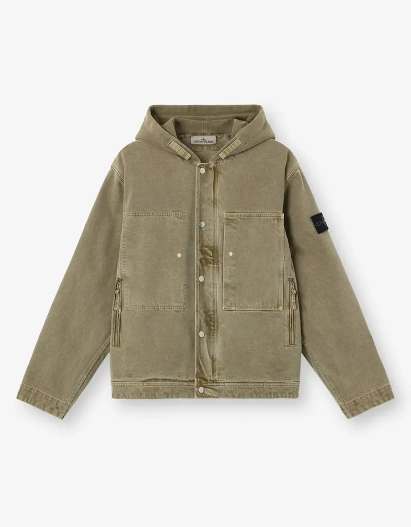 A hooded utility jacket in a muted olive-khaki color, featuring a snap-button front, chest pockets, zippered hand pockets, and a black rectangular patch on the left sleeve, displayed on a clean white background.