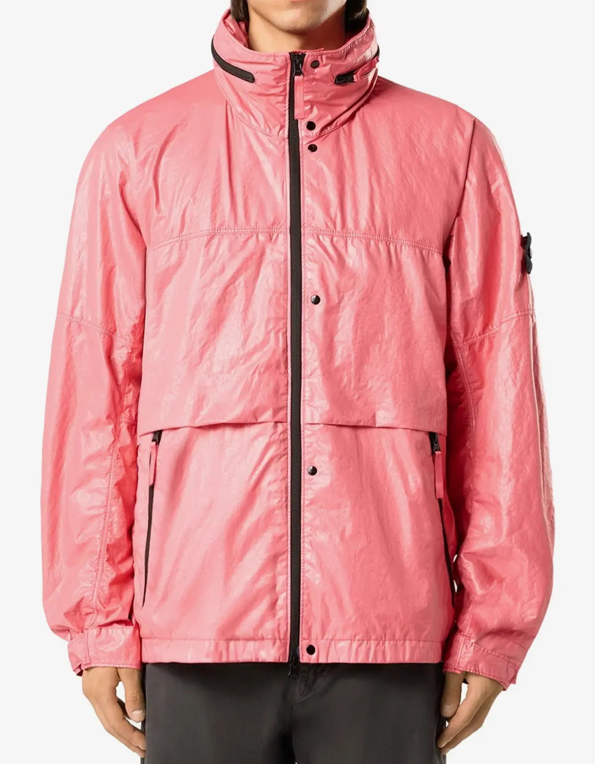 A pink lightweight waterproof jacket with black zipper and trim details, worn by a model against a plain white background.