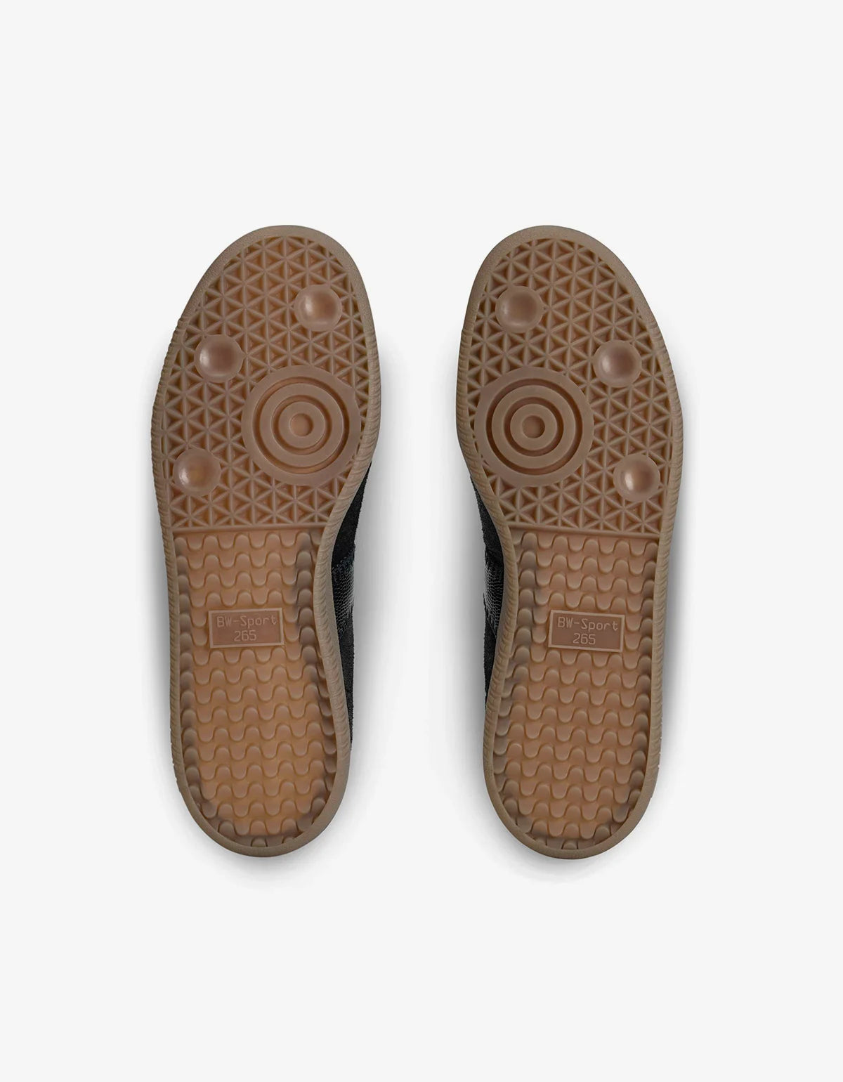 A pair of brown rubber shoe soles viewed from above, showing textured tread patterns and circular grip details, set against a plain light gray background.