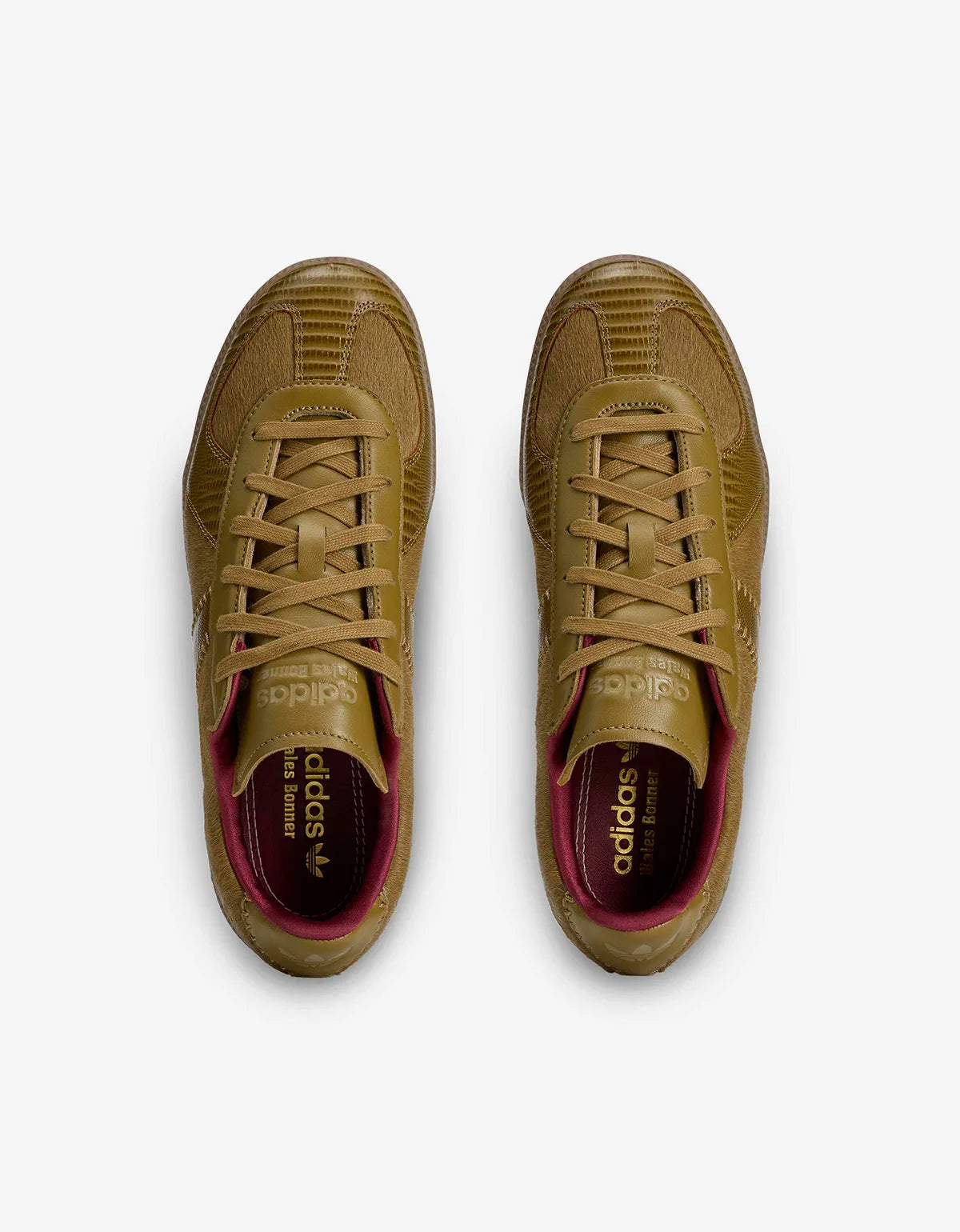 A pair of Adidas Superstar sneakers in a monochromatic tan/khaki colorway, viewed from a top-down angle on a light gray background.