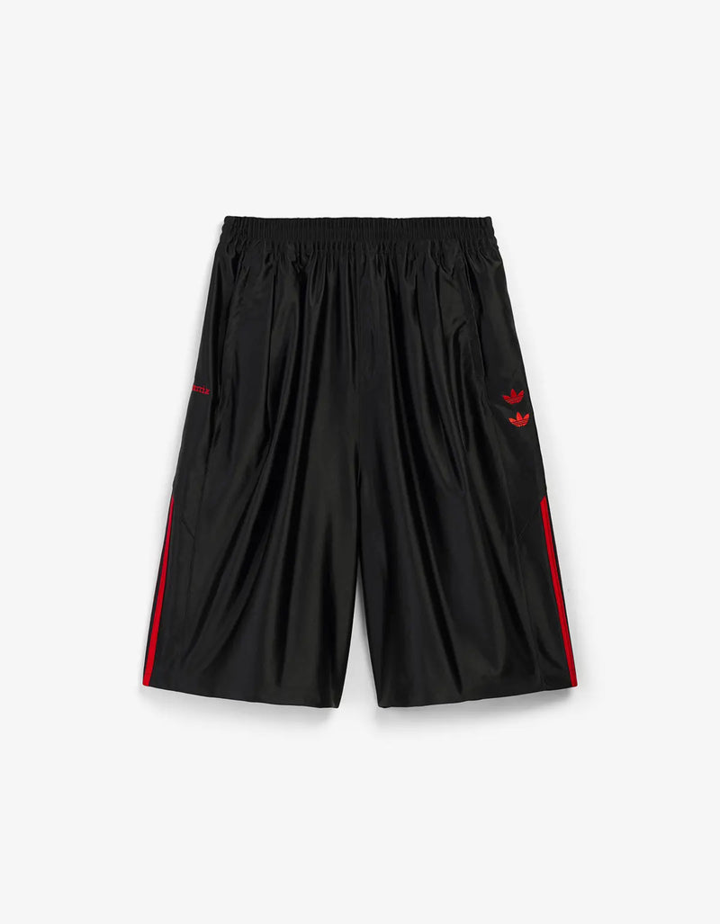 Black athletic shorts with red side stripes and a red logo on the left hip, displayed flat against a light gray background.